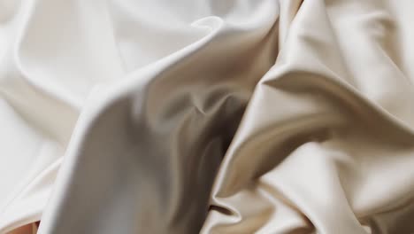 Close-up-of-white-and-beige-shiny-silk-clothes-in-slow-motion