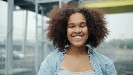 smiling teenager with curly hair outdoors