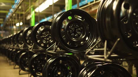 black car wheels in a factory paint shop