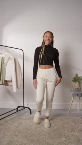 vertical pov video of female social media influencer producing user generated content in studio modelling a variety of fashion outfits shot in real time 5