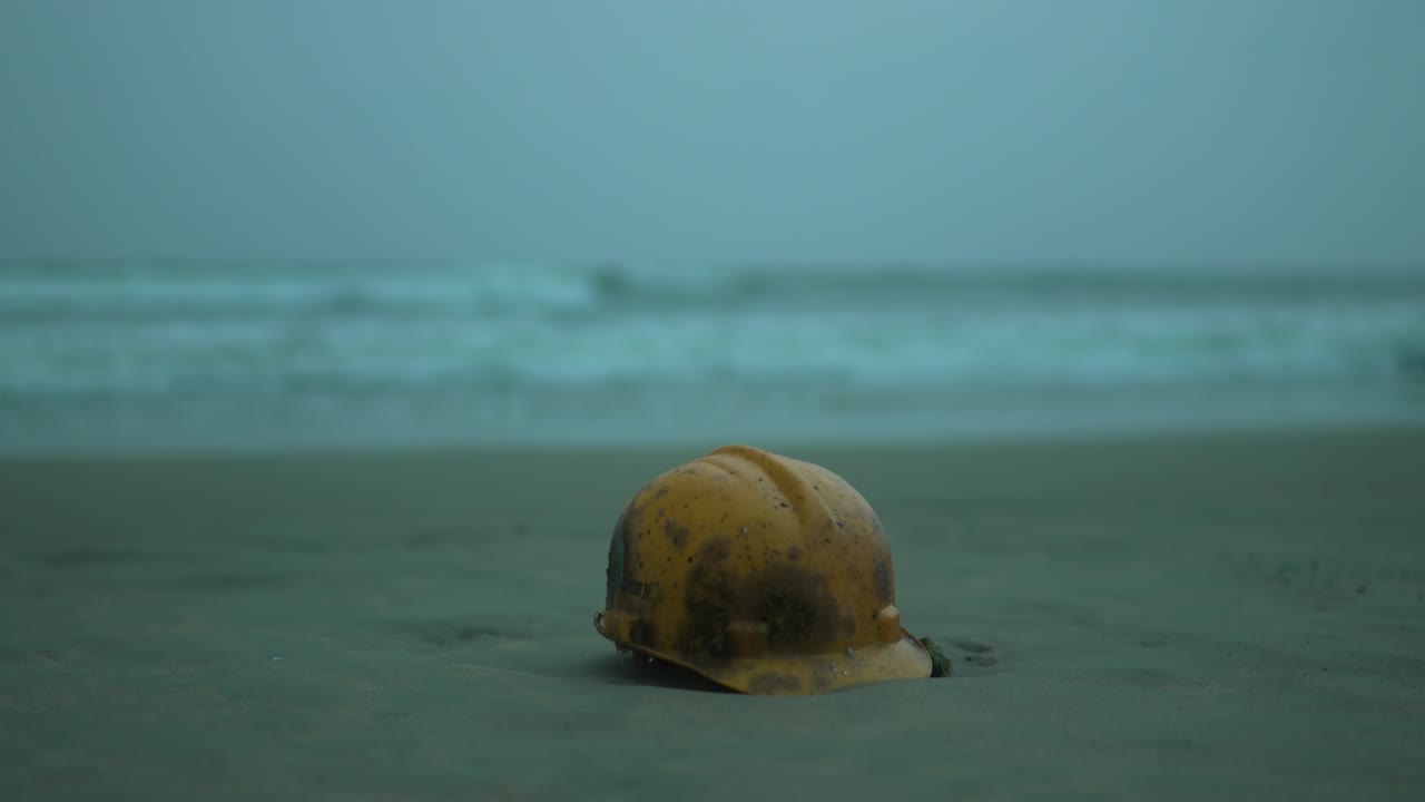 морская ракушка на песчаном пляже с волнами на заднем плане, сумерки