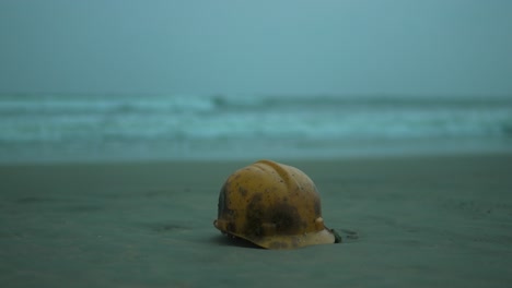 Seashell-on-sandy-beach-with-waves-rolling-in-the-background,-dusk-setting