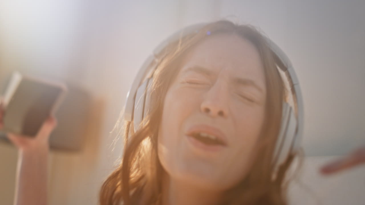 Excited woman dancing headphones in sunlight closeup. Energetic female listening