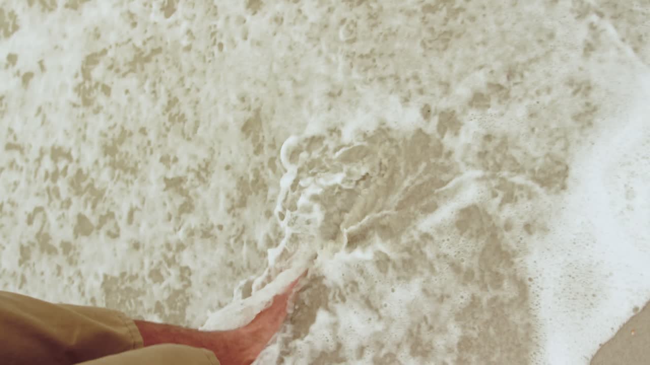 Low section of man walking barefoot on the beach 4k