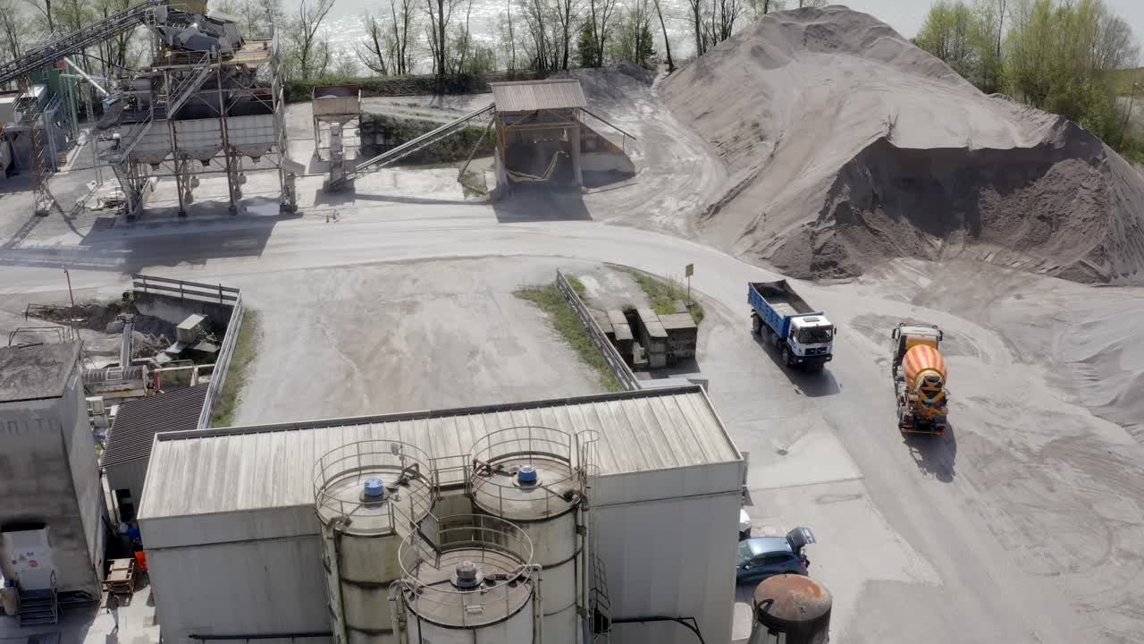 Panoramic drone movement above the industrial quarry site with moving loading truck.
