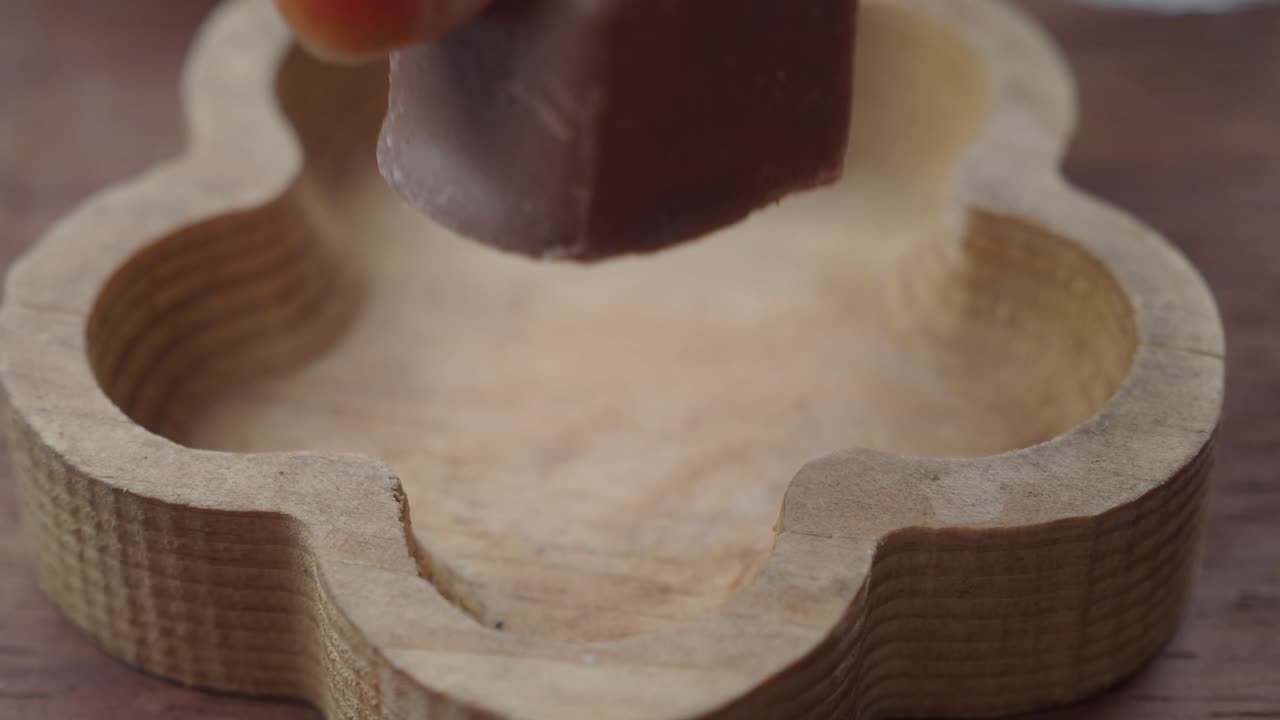 primer plano de un pedazo de chocolate en un plato de madera