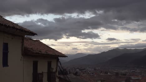 clouds over moody cityscape of cusco with mountain panorama, peru