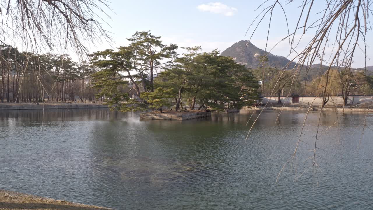 Pond With Artificial Island At Gyeongbokgung Palace In Seoul, South Korea. Mountain In Distant Background. wide shot