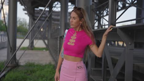 woman striking a pose next to a railway line, radiating beauty and confidence