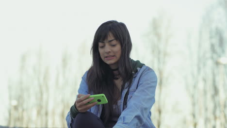 Stilvolles-Teenager-Mädchen,-Das-Smartphone-Benutzt,-Während-Es-Draußen-Sitzt.