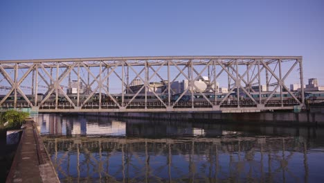 JR-Train-Traveling-Over-Bridge-in-Taisho,-Osaka-Japan