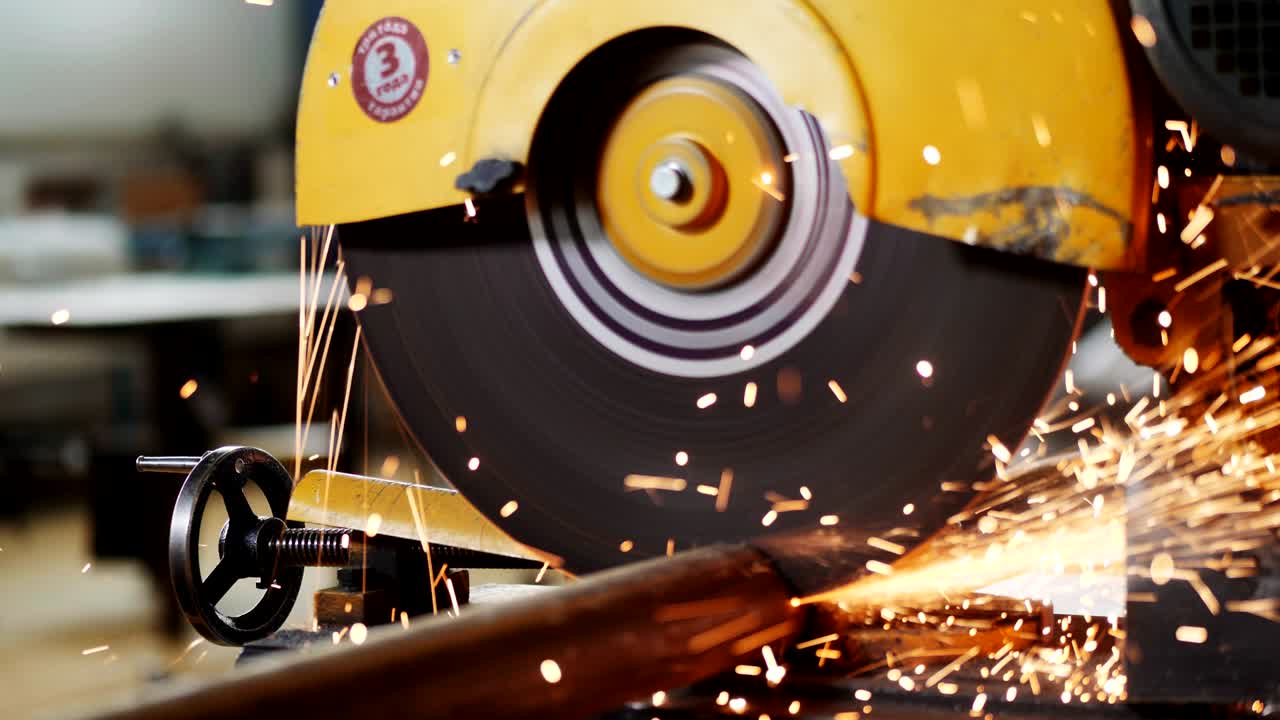 trabajador corta tubos metálicos con sierra en la planta de producción de cerca