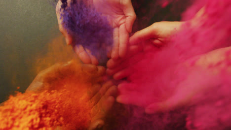 video of multi coloured powders over hands with copy space