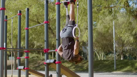 atleta masculino con pierna artificial haciendo ejercicios de anillos de gimnasia.