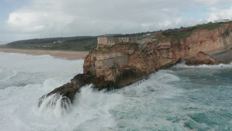 antena del fuerte de são miguel arcanjo con altas olas formando y rompiendo en las rocas frente al acantilado