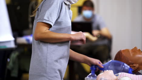 training course for first aid. medical worker giving instructions for saving life in resuscitation center. dummies for demonstration on the table.