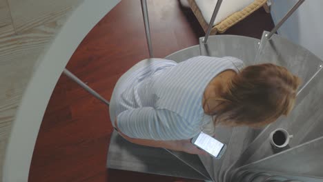 Woman-with-Smartphone-Drinking-Coffee-on-Spiral-Stairs