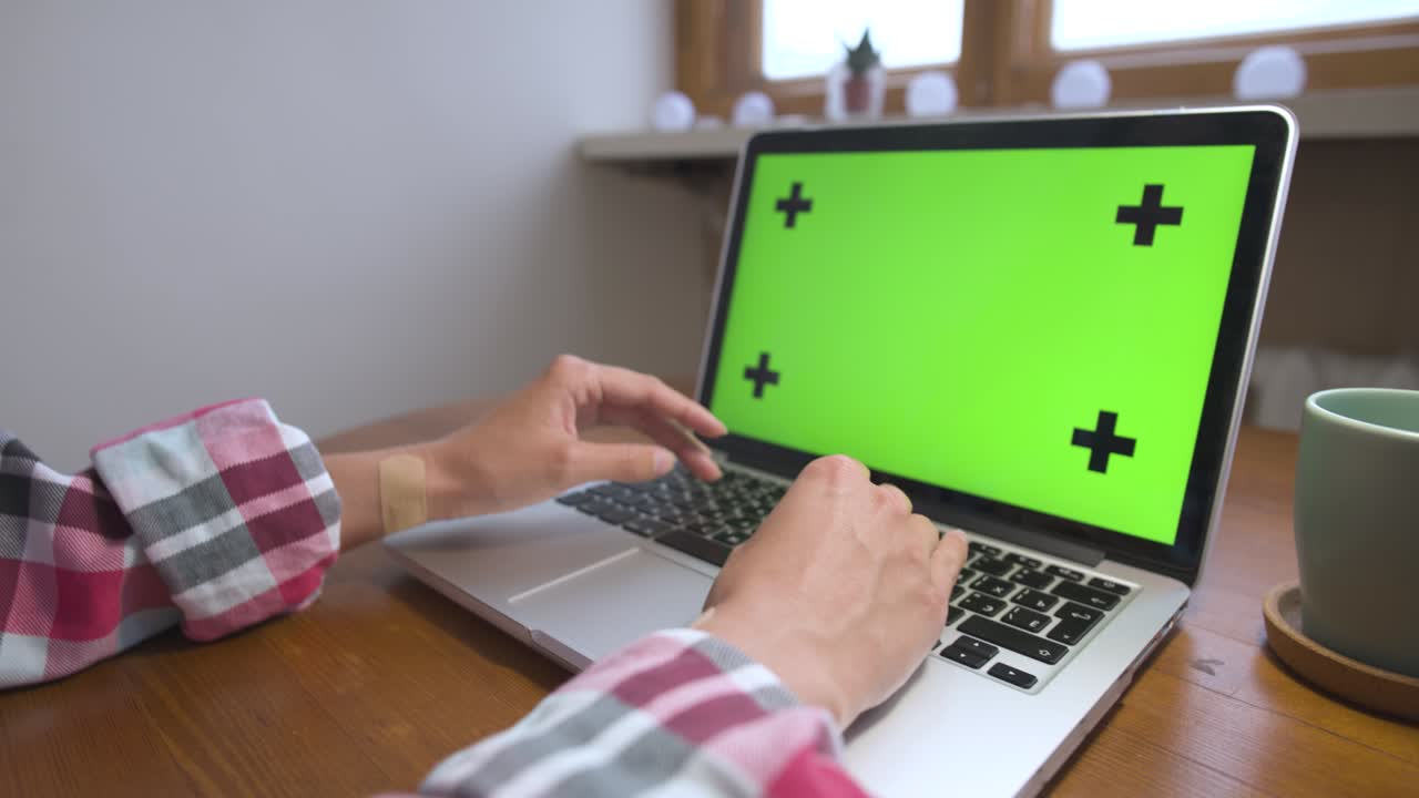 mujer usando portátil con pantalla verde. negocio, comunicación, freelance y concepto de internet. trabajando en un portátil en casa