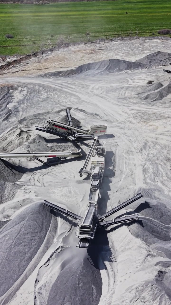 Vista aérea de maquinaria industrial y montones de grava en cantera de granito