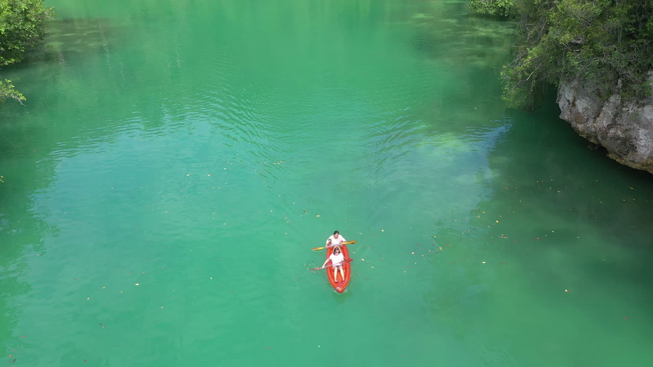 열대 호수 에서 카야크 를 타는 부부