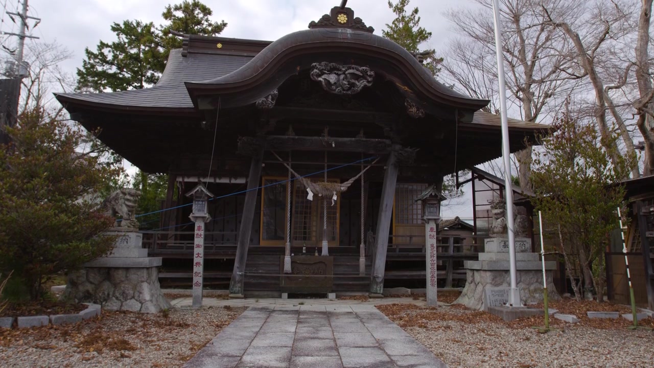 曇り空の下、日本の伝統的な神社を捉えた広角の固定ショット。