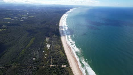 waves splashing on sandy shore of belongil beach in byron bay, new south wales, australia