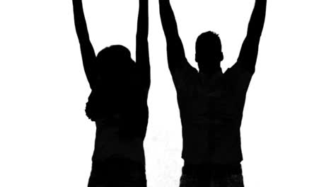 silhouette of couple jumping and raising arms on white background