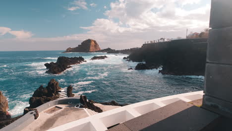 pov shot walking towards waves crashing the shore of sunny porto moniz, madeira