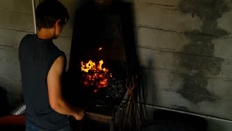 female metalsmith heating horseshoe in fire 4k