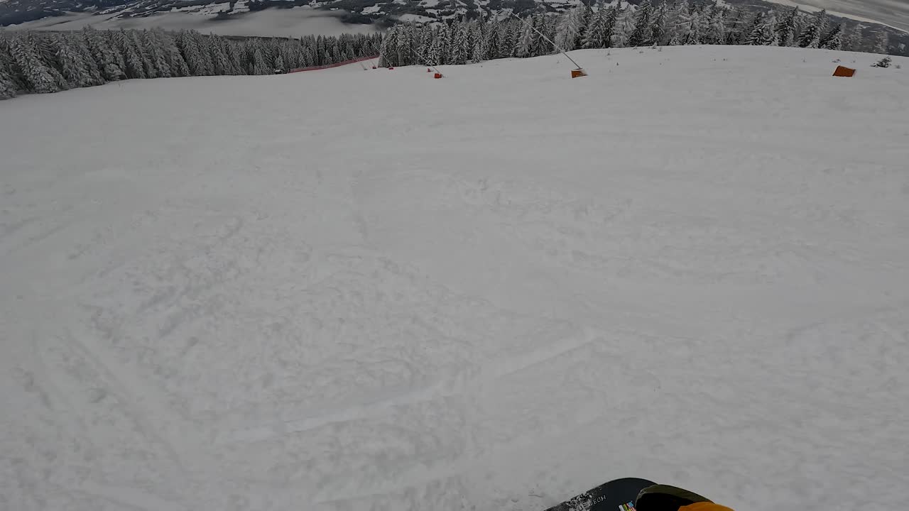 POV snowboarder principiante che pratica curve controllate su pista invernale.