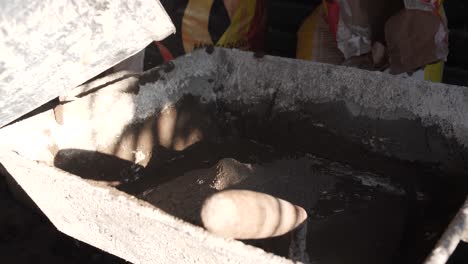 primer plano de agua que se vierte en una cuenca en un sitio de construcción, la luz del sol proyectando sombras
