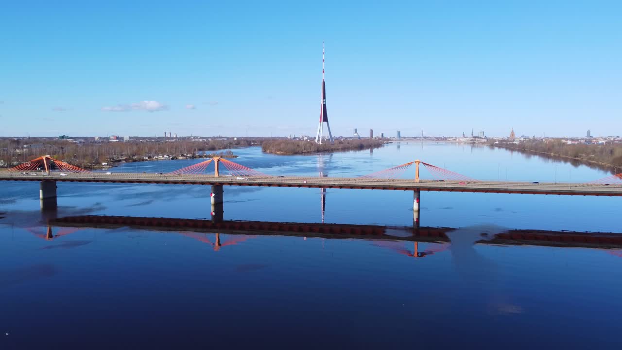 Aerial forward shot of Southern Bridge in Riga with cars passing, sunny day