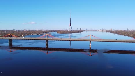 aerial forward shot of southern bridge in riga with cars passing, sunny day