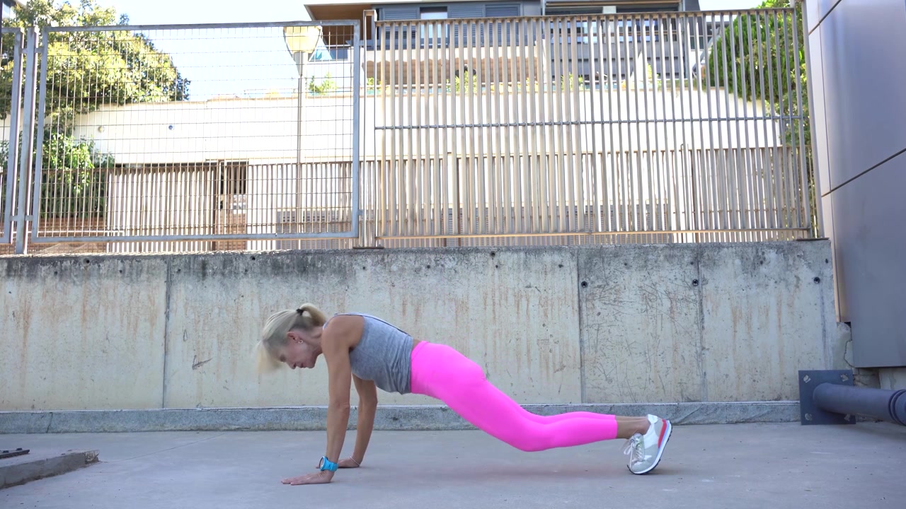 Donna in forma che esegue plank e salti durante l'allenamento.