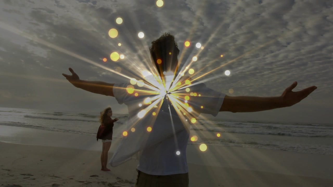 Vertical video: Couple posing for beach portrait while starburst appearing, expanding over subjects