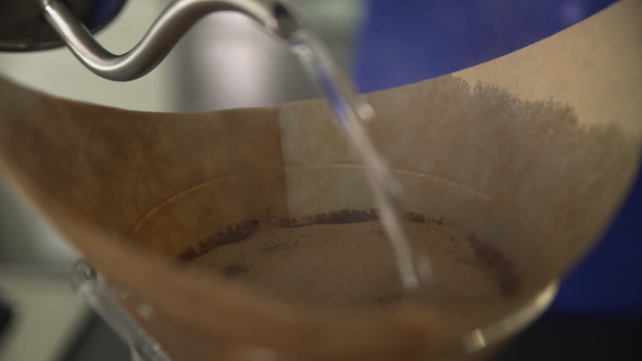 Closeup of Boiling Water Pouring into Coffee Filter with Steam, Slow Motion