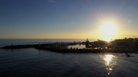 Aerial-shot-of-a-small-fishing-harbor-during-magic-hour