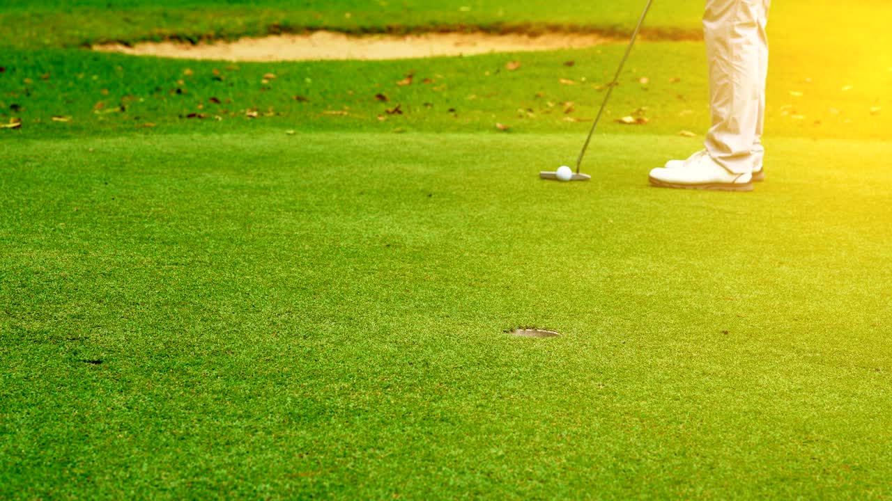 골프 스포츠 개념: 골퍼가 밝은 해가 지는 아름다운 골프 코스에서 골프 공을 구으로 던져 우승자에게.