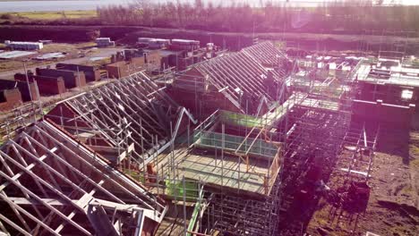 Unfinished-waterfront-townhouse-framework-and-scaffolding-development-construction-site-aerial-view