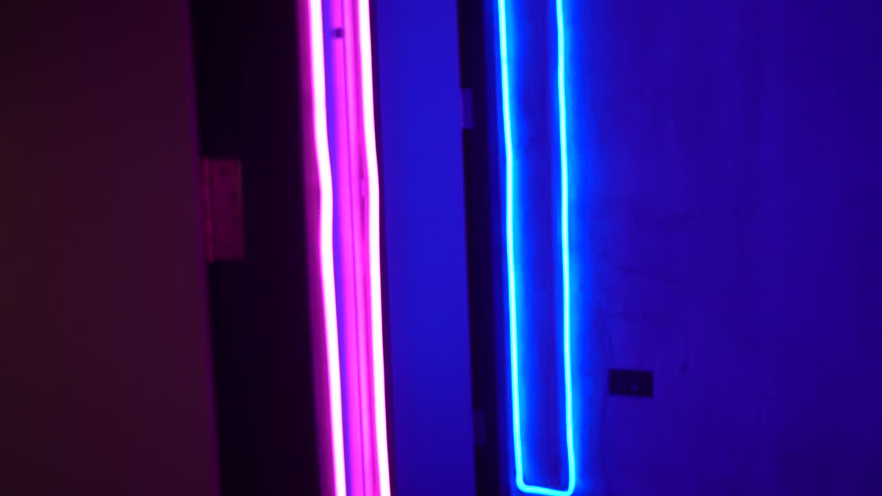 luz de borde de neón azul y rosa a lo largo de la pared interior del club nocturno y el borde de la puerta