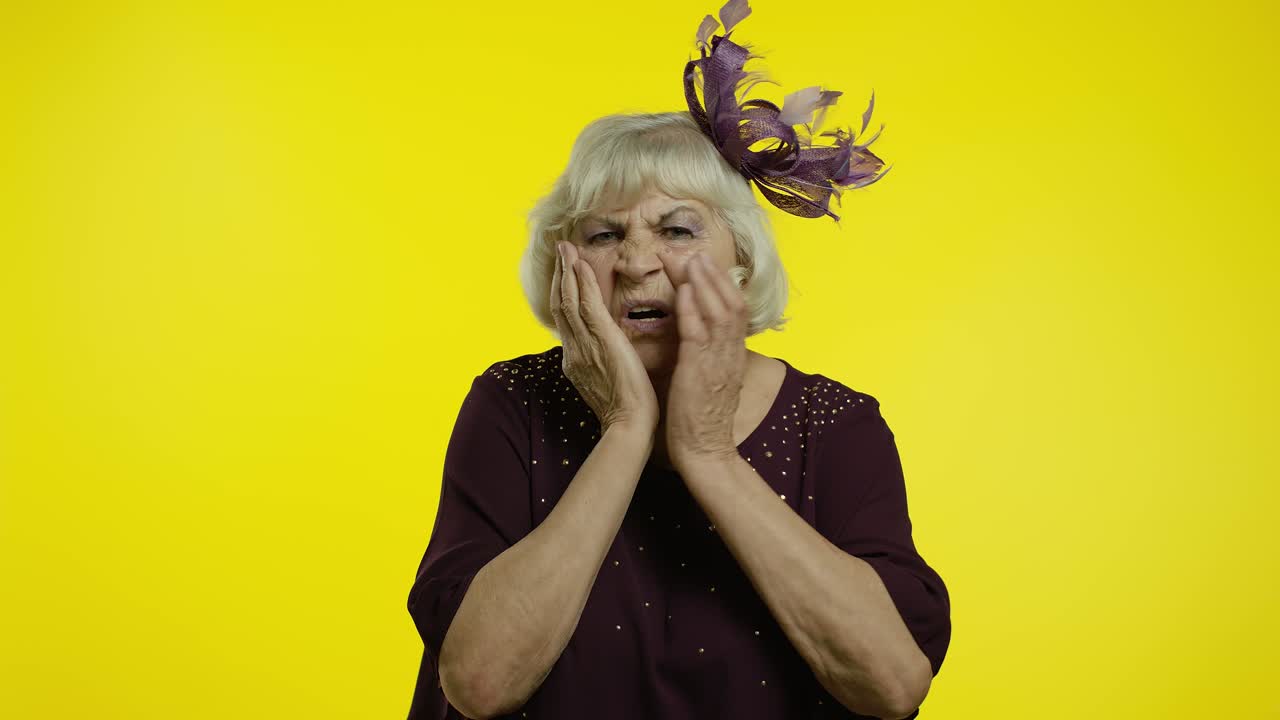 Dental problem. Unhealthy old woman touching sore cheek, suffering terrible toothache, horrible pain