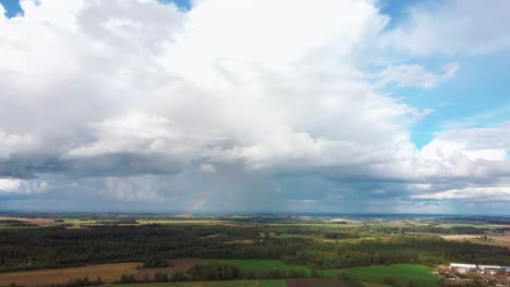 El-Arco-Iris-Sobre-El-Campo-De-Cultivo-Con-Trigo-Floreciente,-Durante-La-Primavera,-Vista-Aérea-Bajo-Nubes-Pesadas-Antes-De-La-Tormenta-7