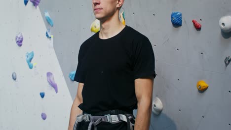 hombre escalando roca en un gimnasio cubierto