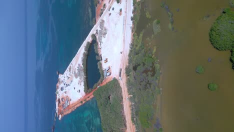 vertical drone shot of cabo rojo port during construction site with blue caribbean sea in background