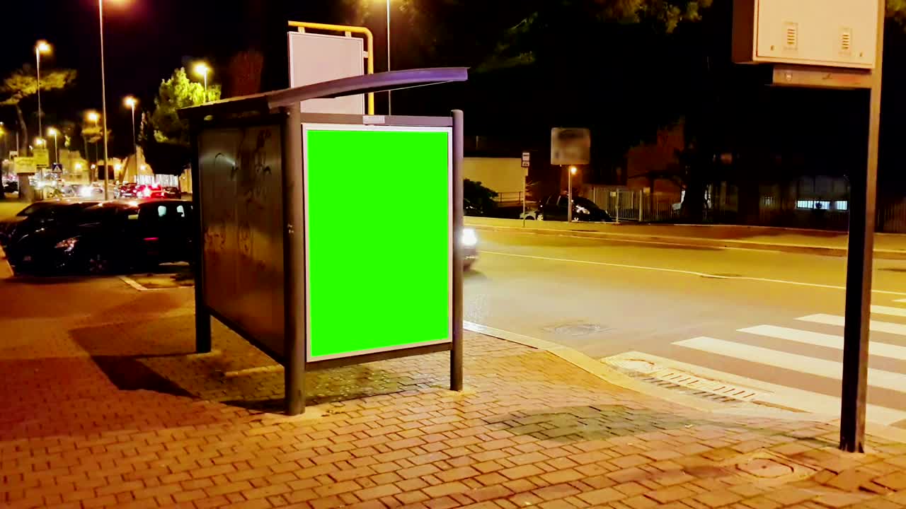cartellone pubblicitario con una schermata verde chiave croma su un traffico auto città strada notturna, notte leggera, pubblicità