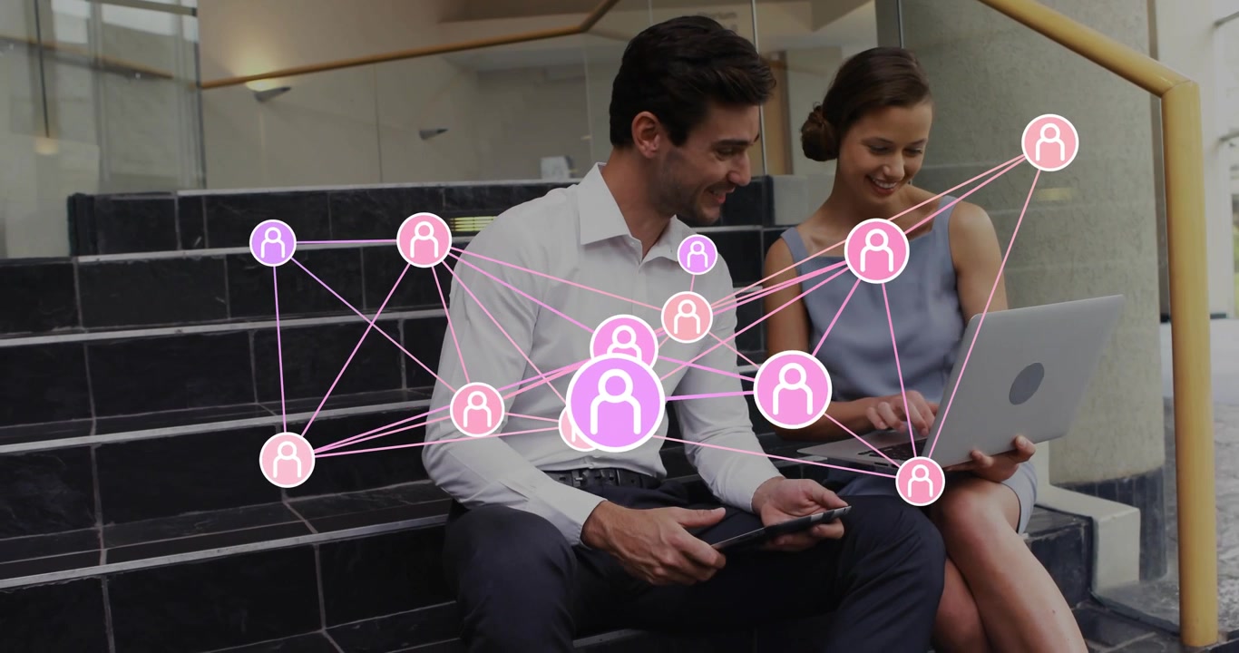 Due colleghi che toccano laptop e tablet sulle scale, con una sovrapposizione tecnologica rosa che si centra, mostrando connessioni
