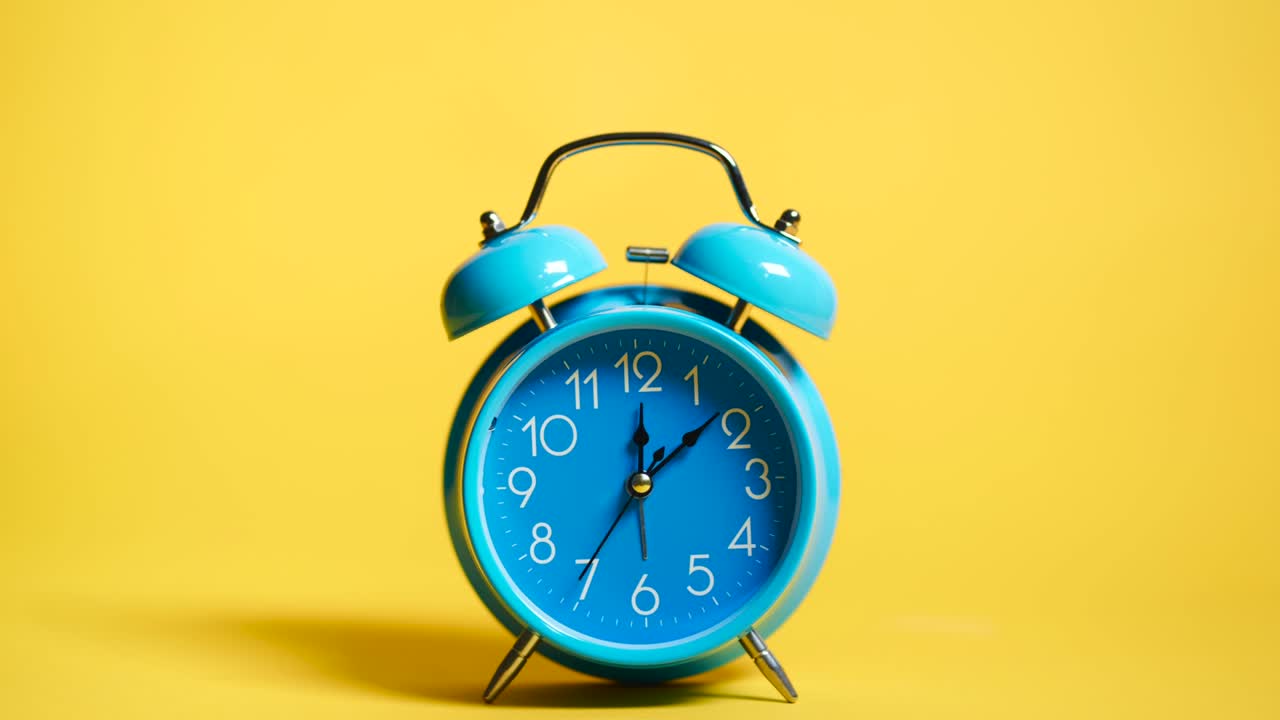 노란색 배경에 레트로 파란색 알람 시계의 타임 스 비디오