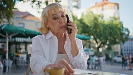 dueño de un negocio jubilado llamando por teléfono en un restaurante callejero. mujer hablando