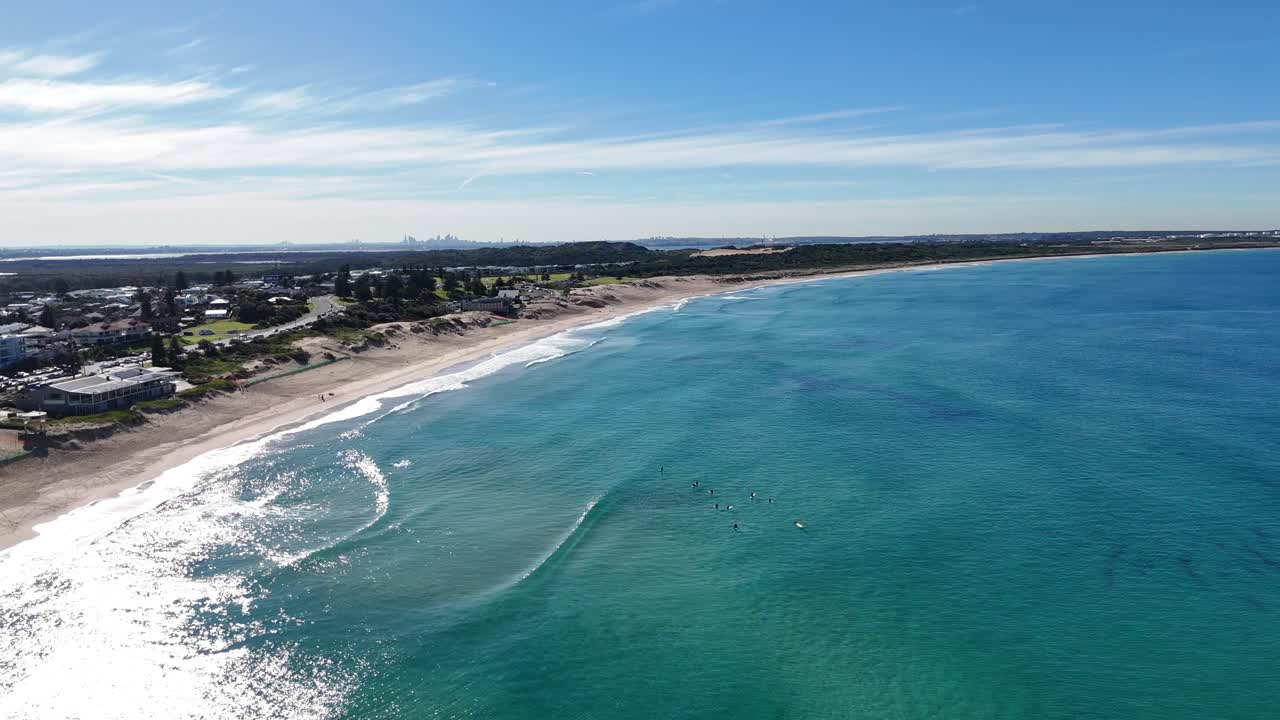 Drone of Cronulla beach stretching far with gentle waves and crystal-clear sea, Sydney NSW Australia
