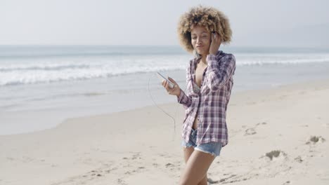 Junge-Frau-Hört-Musik-Am-Strand